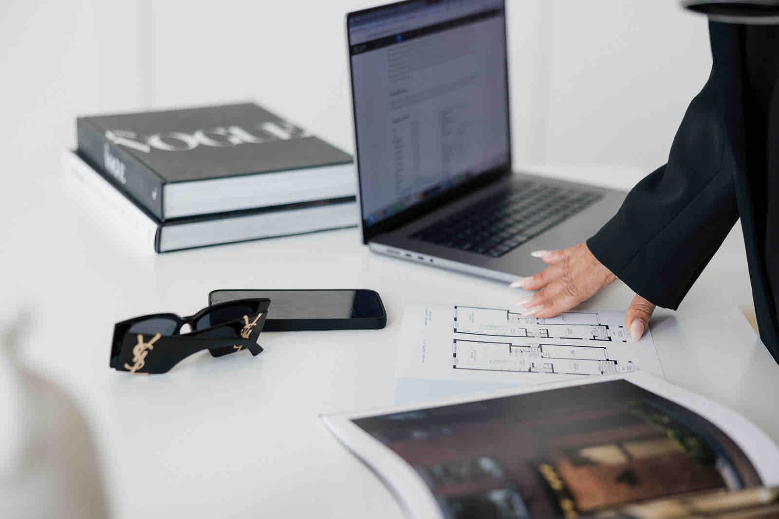 Reviewing a floor plan beside a laptop.